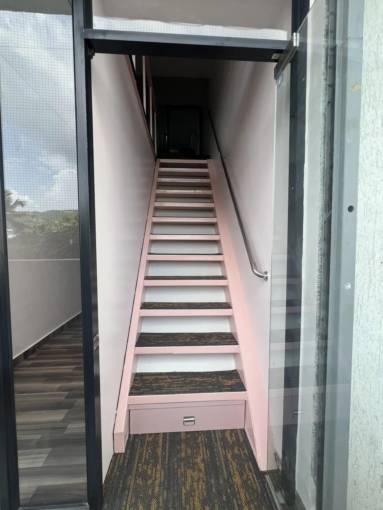Pink staircase up to the small offices on the upper level